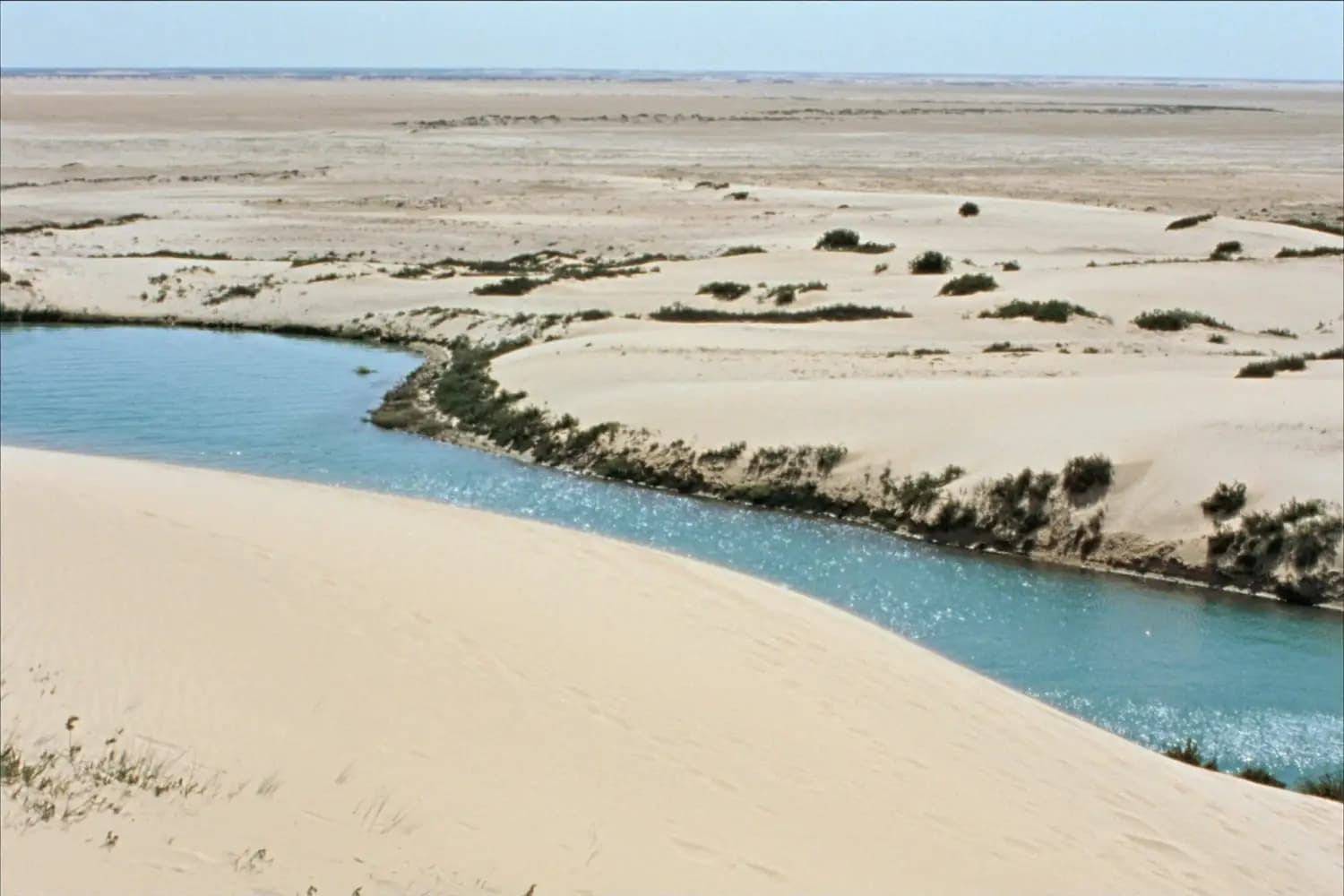 White sand meeting the turquoise lagoon near Dakhla, a landscape used in The Odyssey