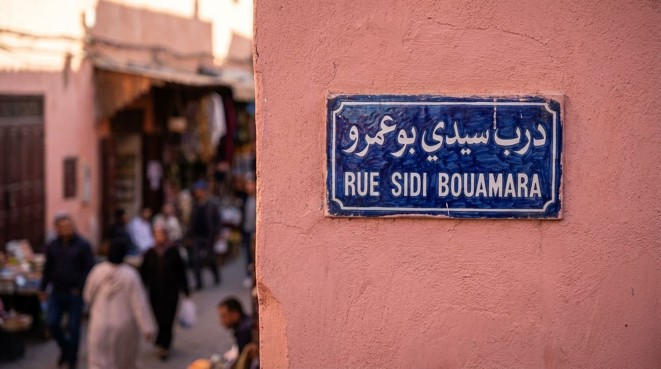 Eine marokkanische Straße mit Laden- und Straßenschildern in arabischer und französischer Schrift.